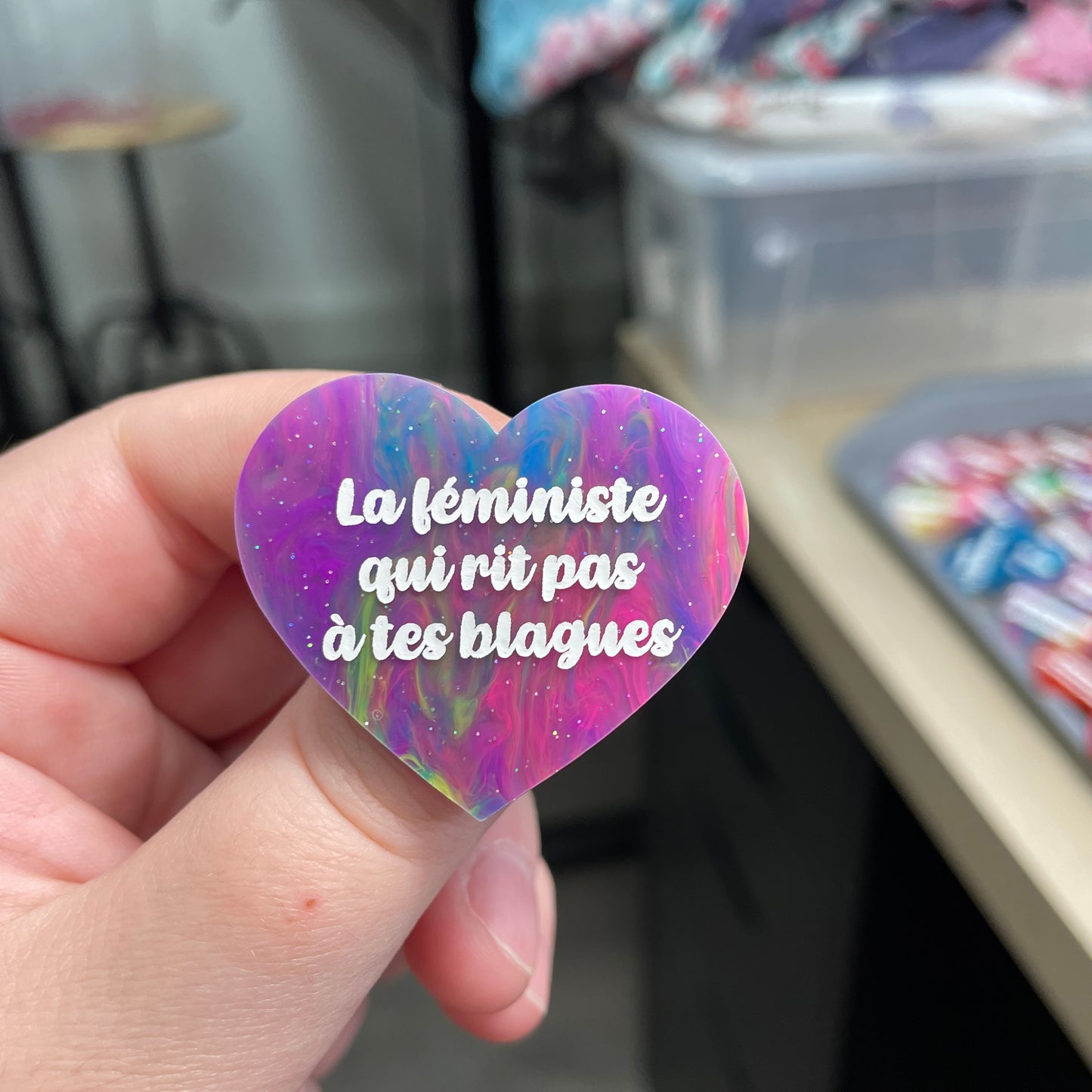 Broche "La féministe qui rit pas à tes blagues" en acrylique semi-transparente marbrée multicolore