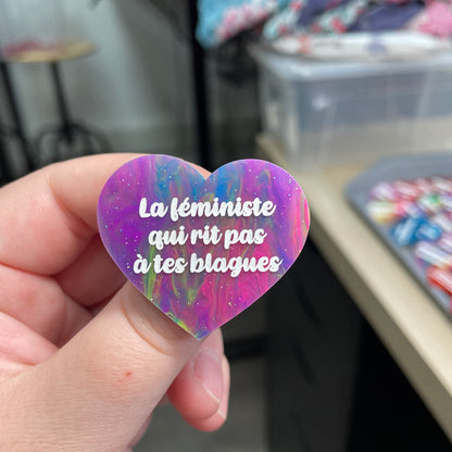Broche "La féministe qui rit pas à tes blagues" en acrylique semi-transparente marbrée multicolore