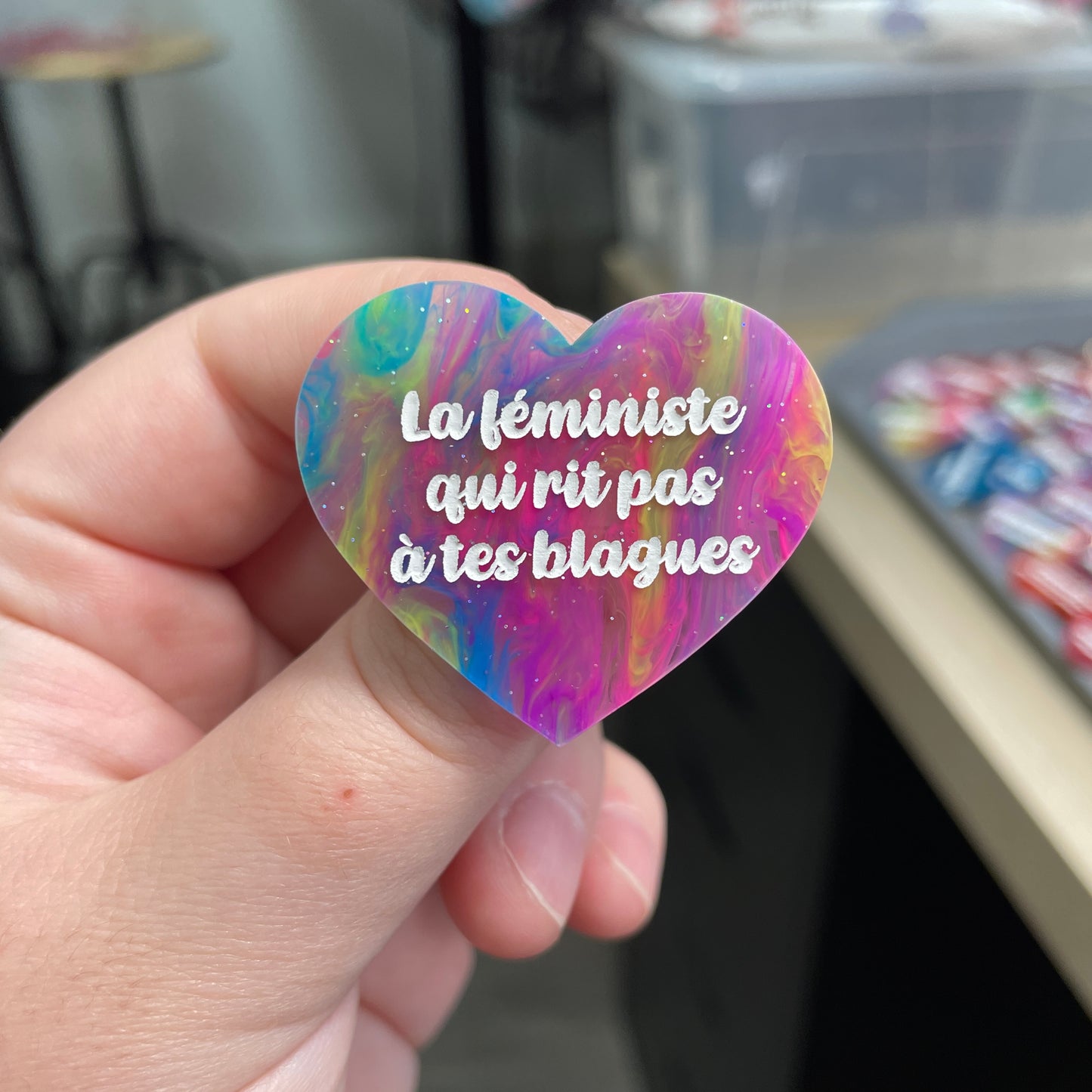 Broche "La féministe qui rit pas à tes blagues" en acrylique semi-transparente marbrée multicolore
