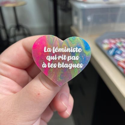 Broche "La féministe qui rit pas à tes blagues" en acrylique semi-transparente marbrée multicolore