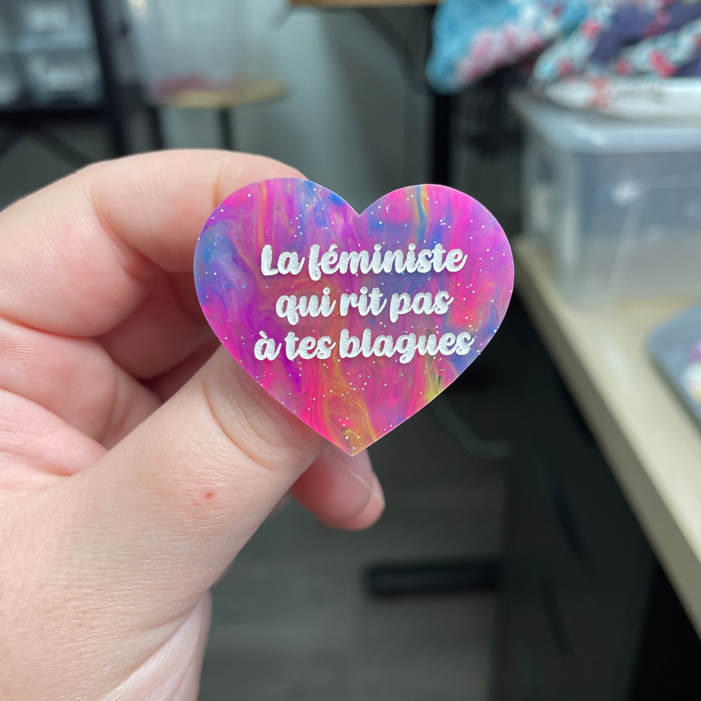 Broche "La féministe qui rit pas à tes blagues" en acrylique semi-transparente marbrée multicolore