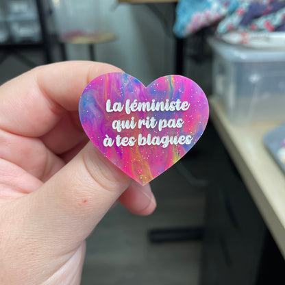 Broche "La féministe qui rit pas à tes blagues" en acrylique semi-transparente marbrée multicolore