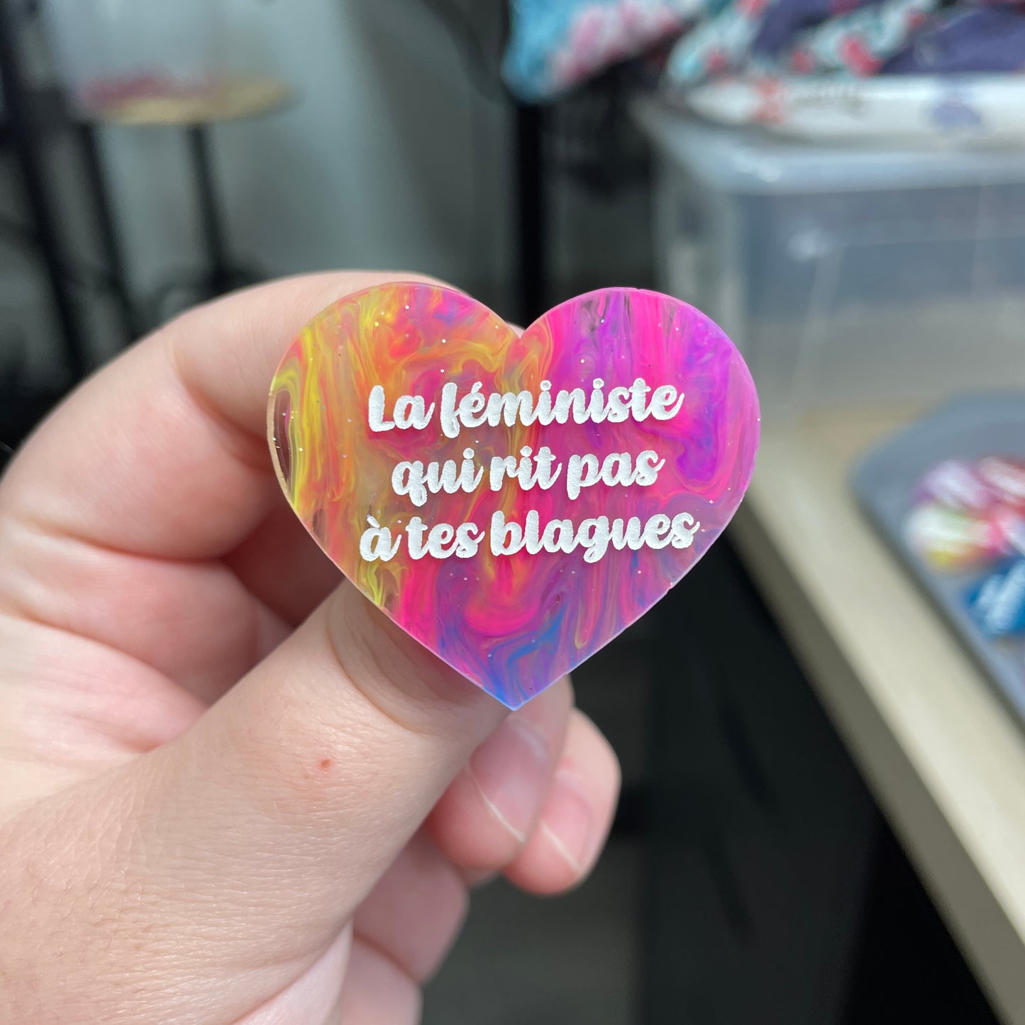 Broche "La féministe qui rit pas à tes blagues" en acrylique semi-transparente marbrée multicolore