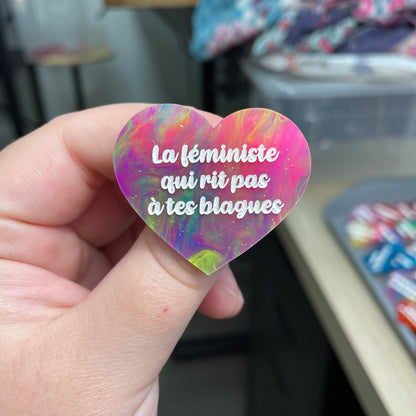 Broche "La féministe qui rit pas à tes blagues" en acrylique semi-transparente marbrée multicolore