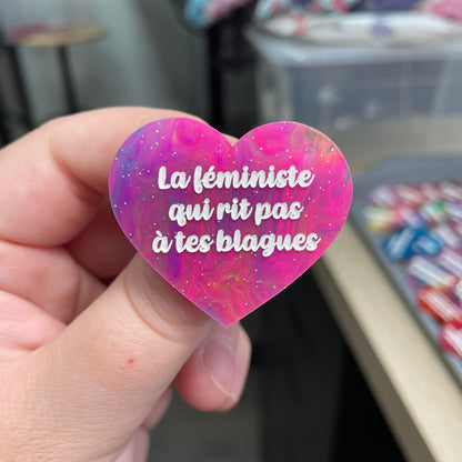 Broche "La féministe qui rit pas à tes blagues" en acrylique semi-transparente marbrée multicolore