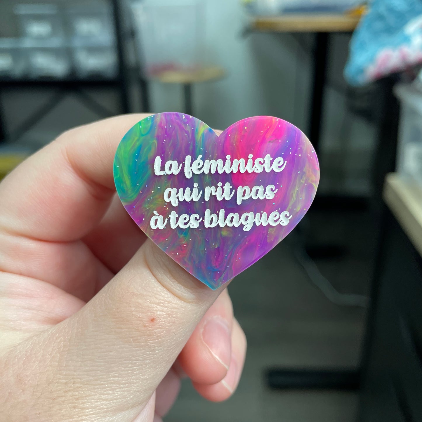 Broche "La féministe qui rit pas à tes blagues" en acrylique semi-transparente marbrée multicolore