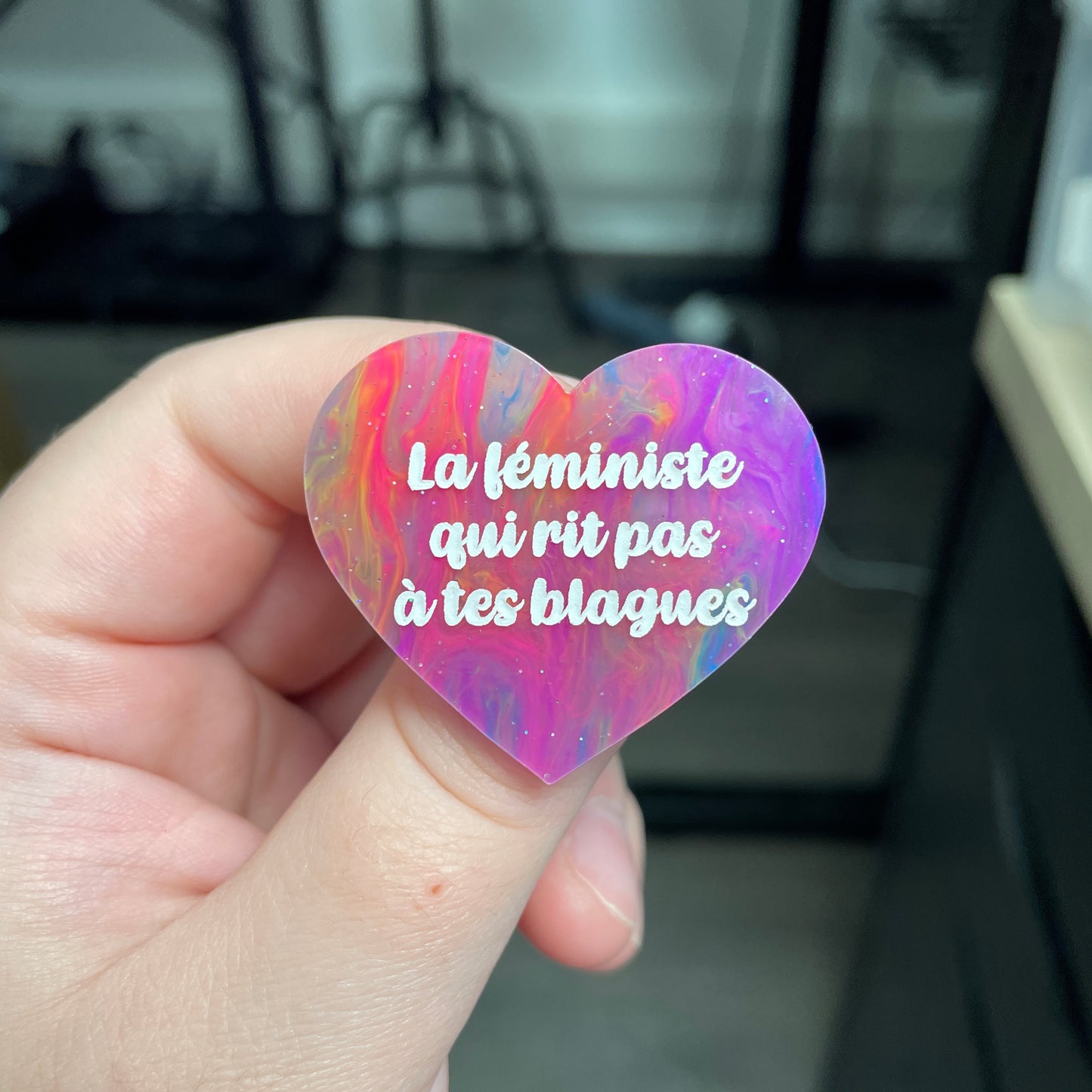 Broche "La féministe qui rit pas à tes blagues" en acrylique semi-transparente marbrée multicolore