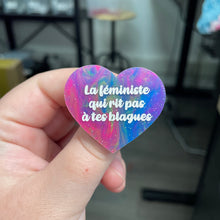 Charger l&#39;image dans la galerie, Broche &quot;La féministe qui rit pas à tes blagues&quot; en acrylique semi-transparente marbrée multicolore