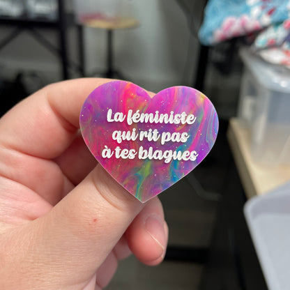 Broche "La féministe qui rit pas à tes blagues" en acrylique semi-transparente marbrée multicolore