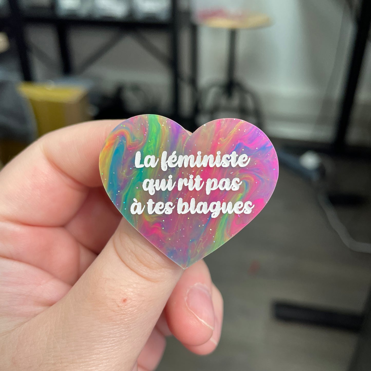 Broche "La féministe qui rit pas à tes blagues" en acrylique semi-transparente marbrée multicolore