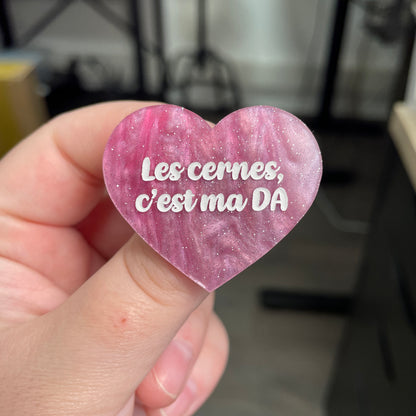 Broche "Les cernes, c'est pas DA" en acrylique marbrée rose et blanche à paillettes