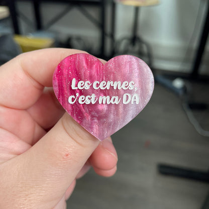Broche "Les cernes, c'est pas DA" en acrylique marbrée rose et blanche à paillettes