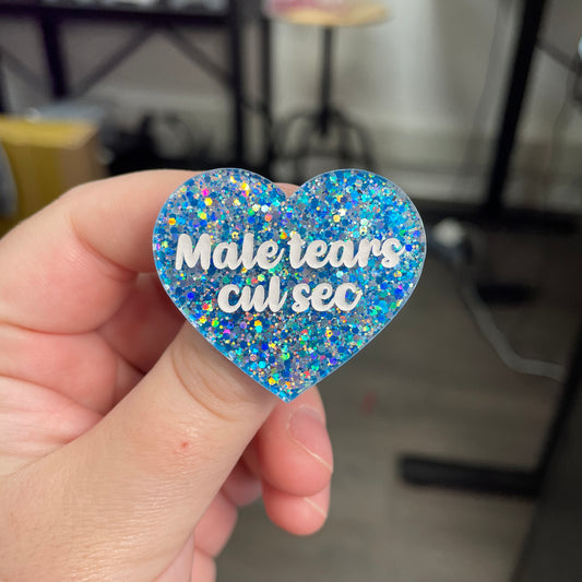 Broche "Mal tears cul sec" en acrylique à paillettes bleues et argentées