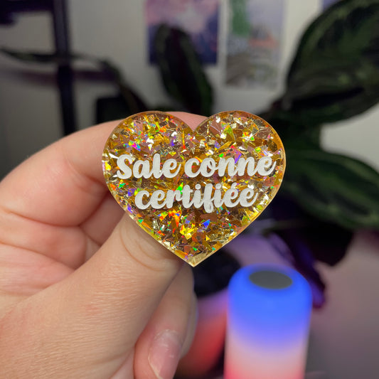 Broche "Sale conne certifiée" en acrylique transparente avec des confettis jaunes