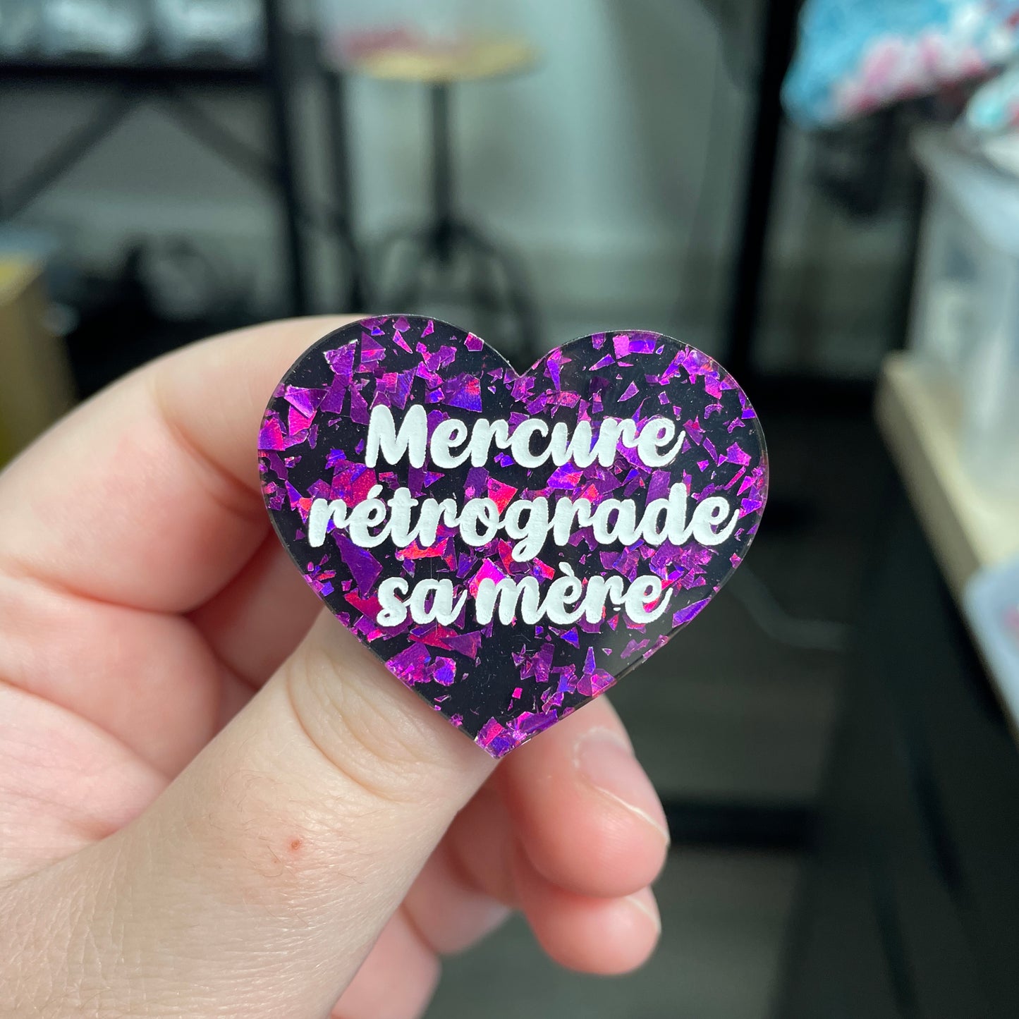 Broche "Mercure rétrograde sa mère" en acrylique noire avec des éclats de confettis violets