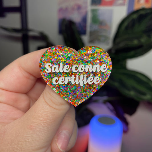 Broche "Sale conne certifiée" en acrylique semi transparente avec des pois multicolores