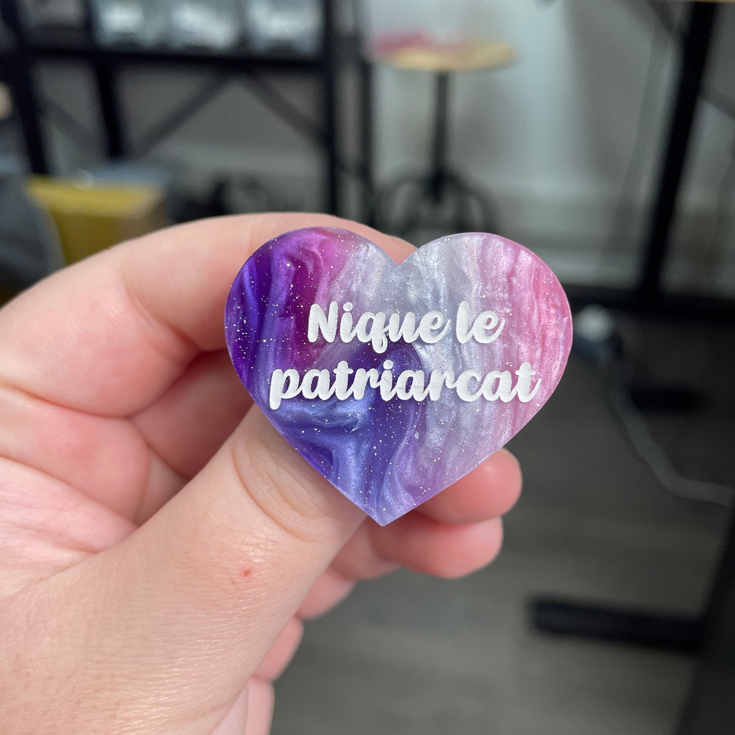 Broche "Nique le patriarcat" en acrylique marbrée bleue, rose et blanche à paillettes