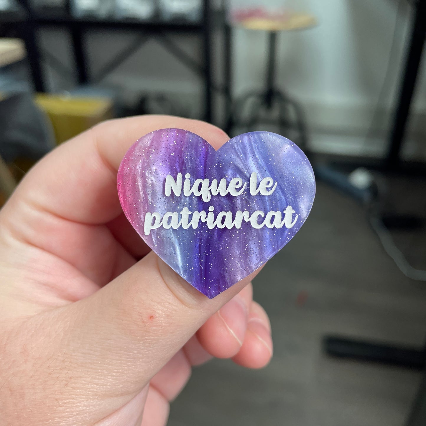 Broche "Nique le patriarcat" en acrylique marbrée bleue, rose et blanche à paillettes
