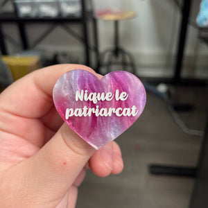 Broche "Nique le patriarcat" en acrylique marbrée bleue, rose et blanche à paillettes