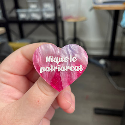 Broche "Nique le patriarcat" en acrylique marbrée bleue, rose et blanche à paillettes