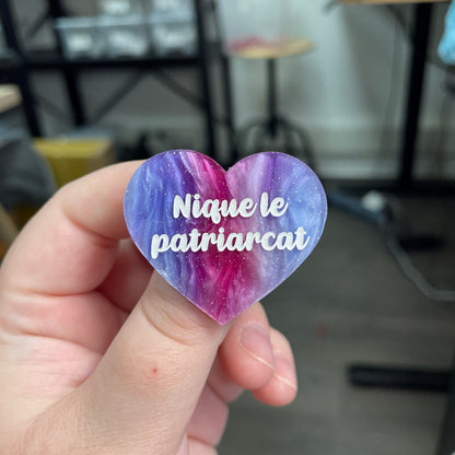 Broche "Nique le patriarcat" en acrylique marbrée bleue, rose et blanche à paillettes