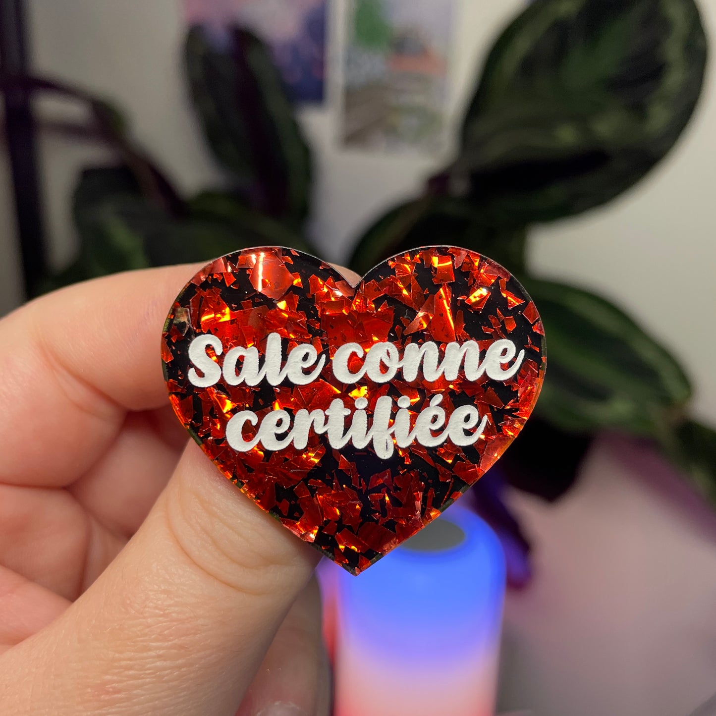 Broche "Sale conne certifiée" en acrylique noire avec des éclats de confettis rouges