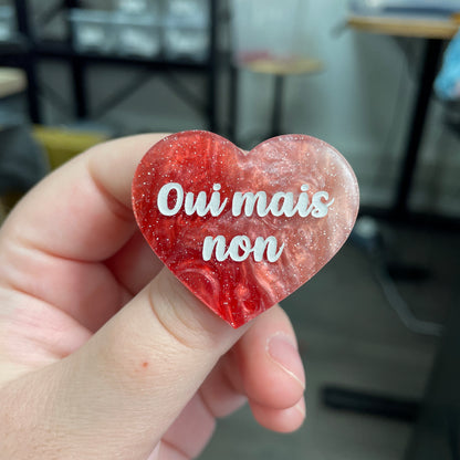 Broche "Oui mais non" en acrylique marbrée rouge, marron et blanche à paillettes