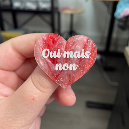 Broche "Oui mais non" en acrylique marbrée rouge, marron et blanche à paillettes
