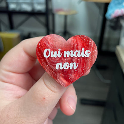 Broche "Oui mais non" en acrylique marbrée rouge, marron et blanche à paillettes