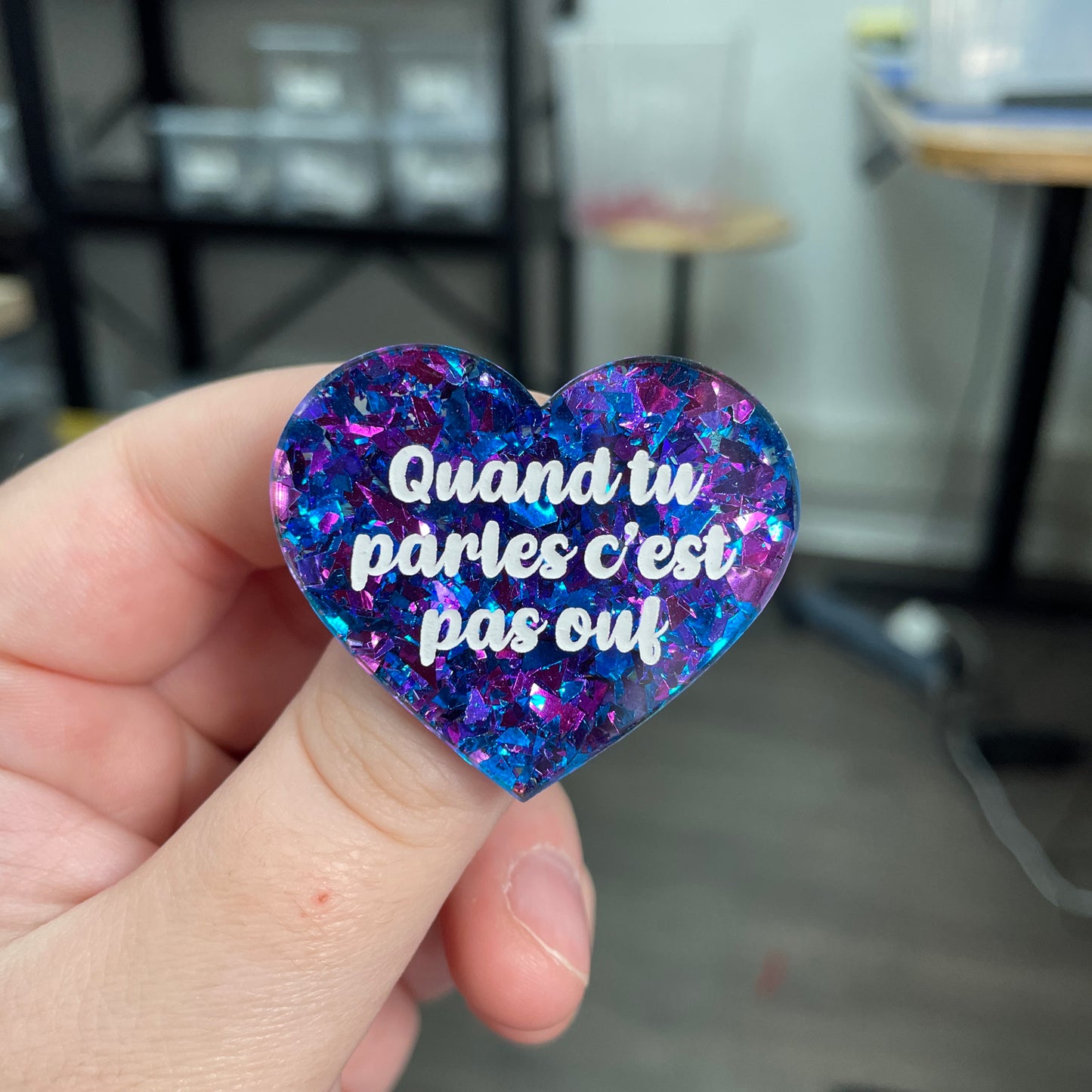 Broche "Quand tu parles c'est pas ouf" en acrylique transparente à gros confettis bleus et violets/roses