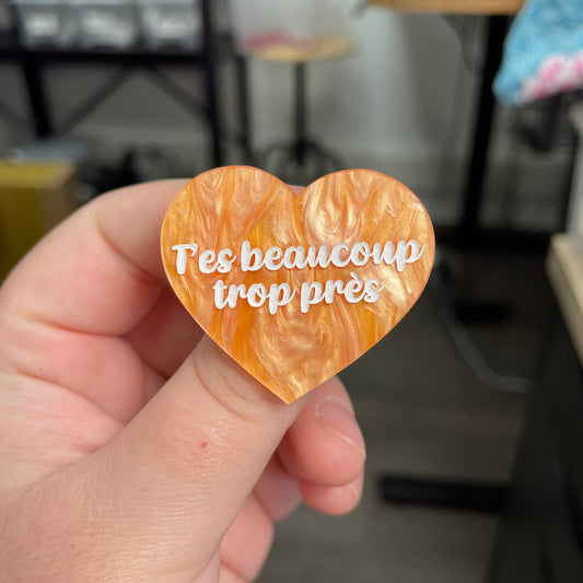 Broche "T'es beaucoup trop près" en acrylique marbrée orange