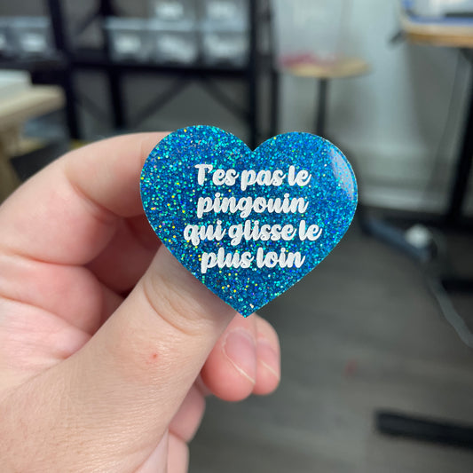 Broche "T'es pas le pingouin qui glisse le plus loin" en acrylique à paillettes bleues