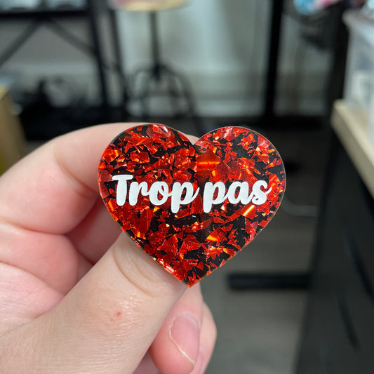 Broche "Trop pas" en acrylique noire avec des éclats de confettis rouges