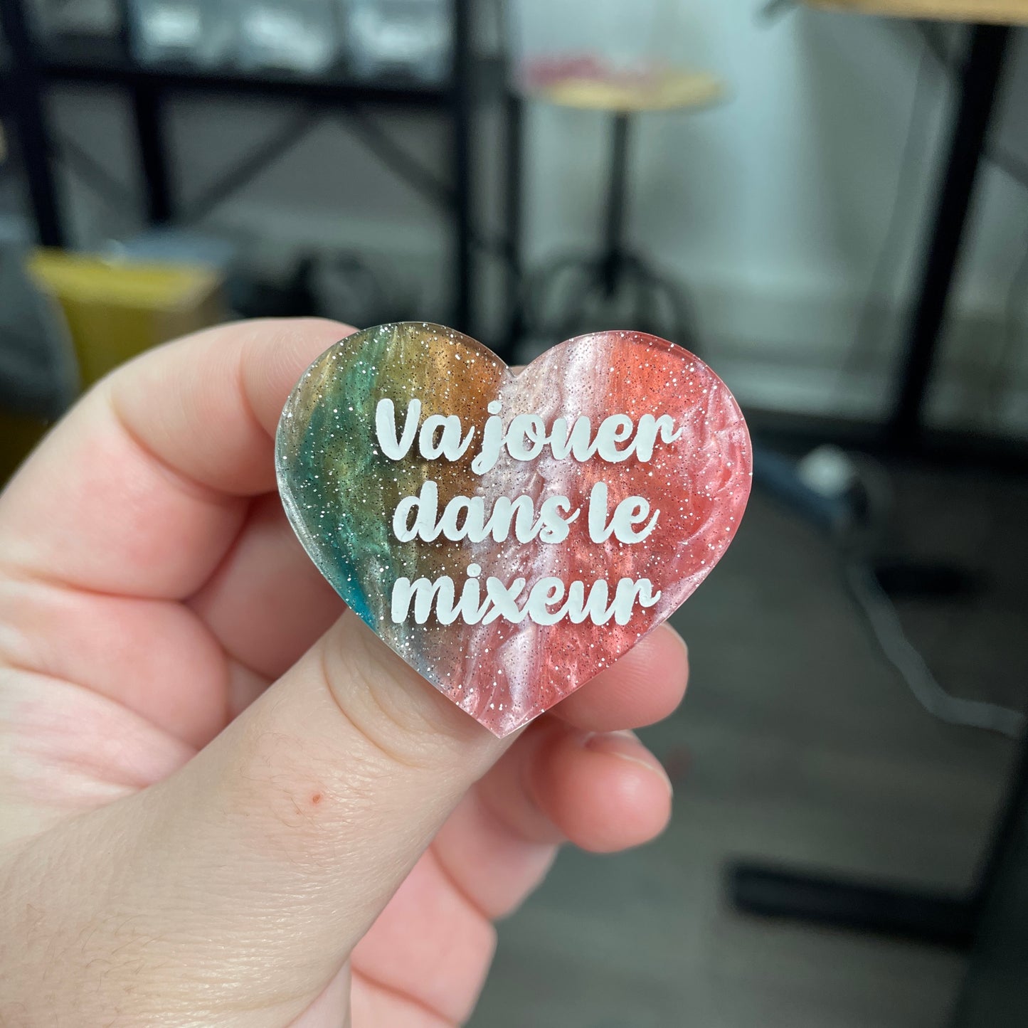 Broche "Va jouer dans le mixeur" en acrylique marbrée verte, rouge, marron et blanche à paillettes
