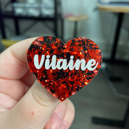 Broche "Vilaine" en acrylique noire avec des éclats de confettis rouges
