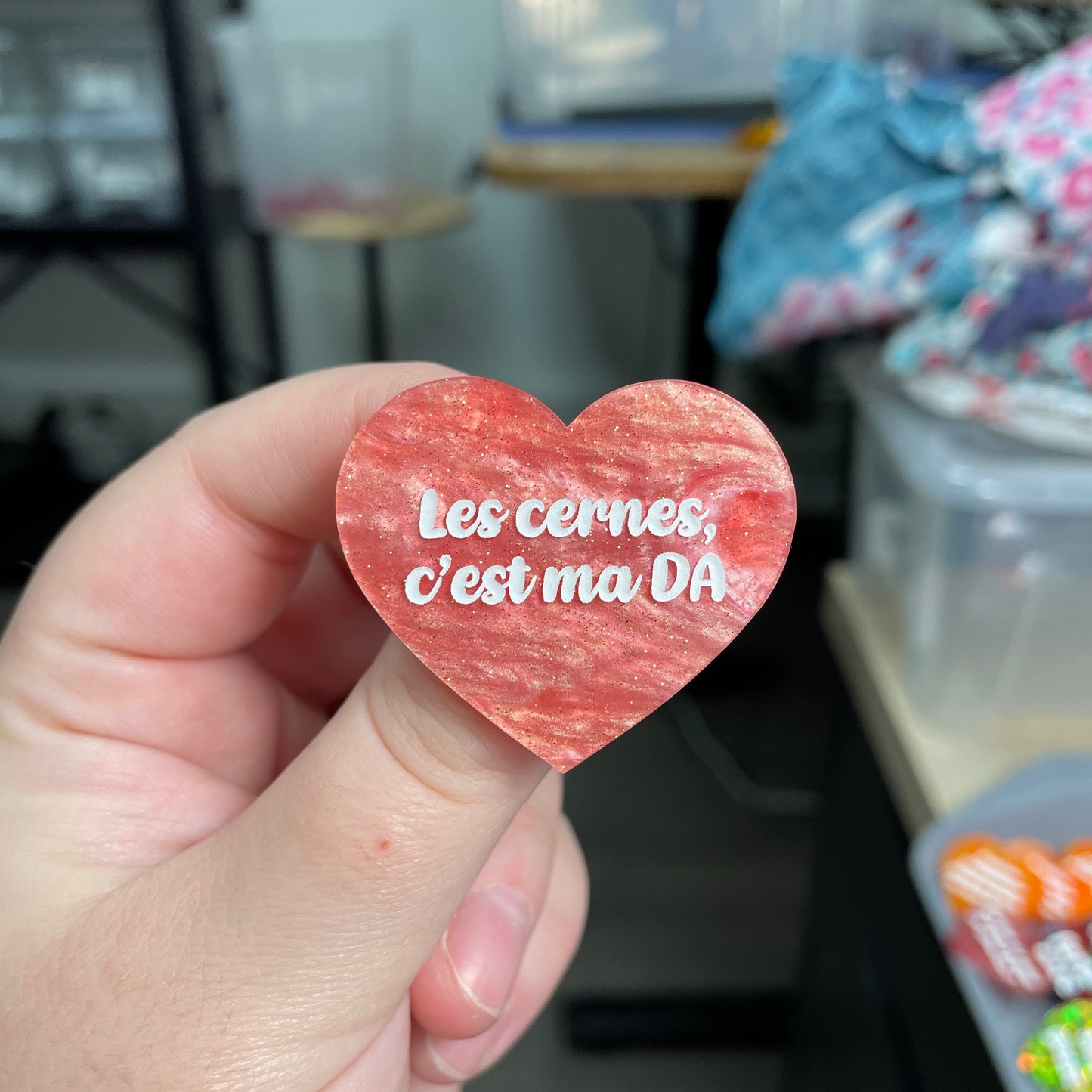 Broche "Les cernes c'est ma DA" en acrylique marbrée rose à paillettes