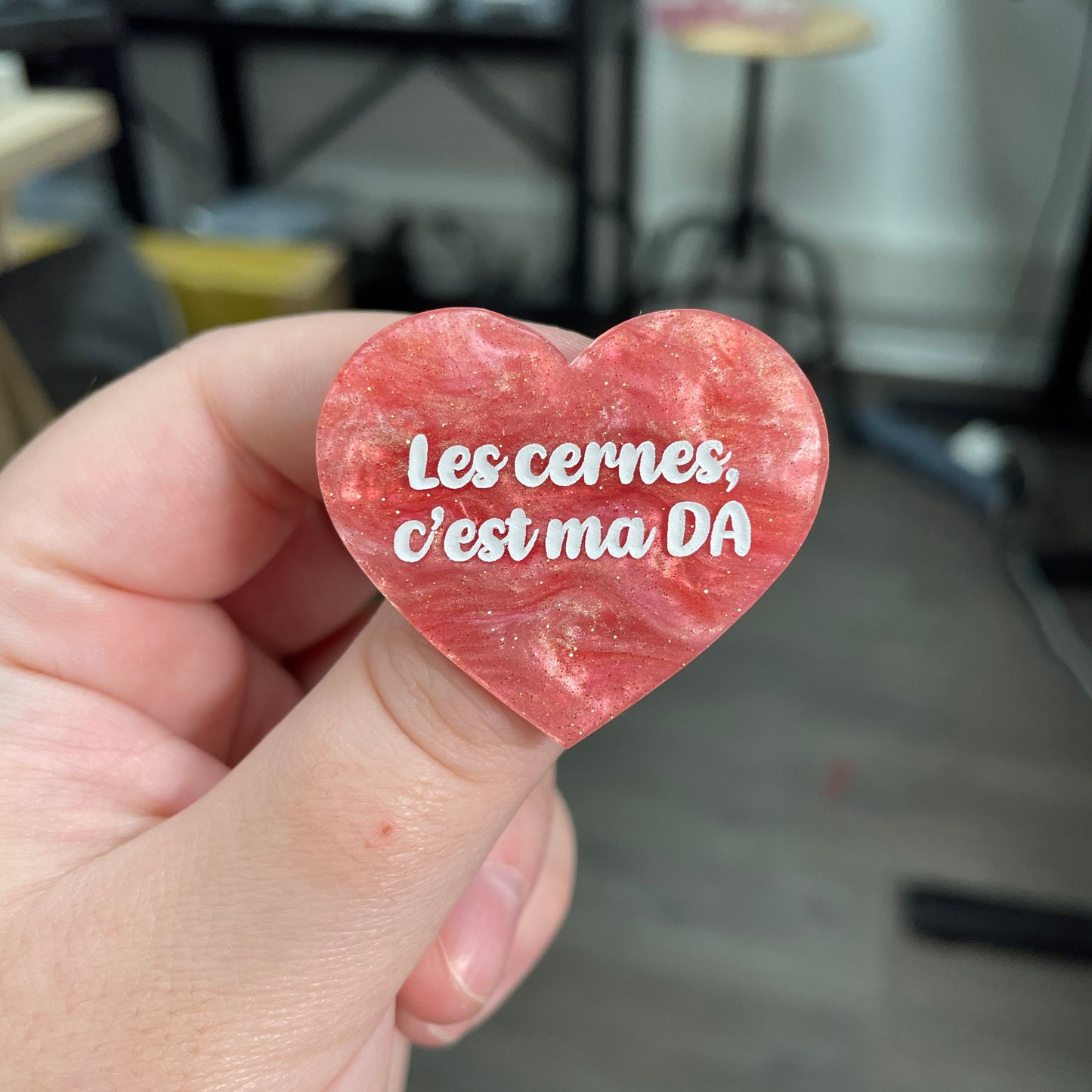 Broche "Les cernes c'est ma DA" en acrylique marbrée rose à paillettes