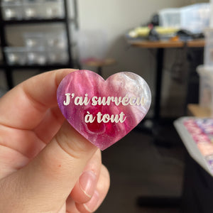 [CONTRÔLE TECHNIQUE] Broche "J'ai survécu à tout" en acrylique marbrée violette, rose et blanche