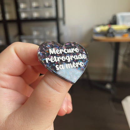 [CONTRÔLE TECHNIQUE] Broche "Mercure rétrograde sa mère" en acrylique semi-transparente avec des confettis noirs