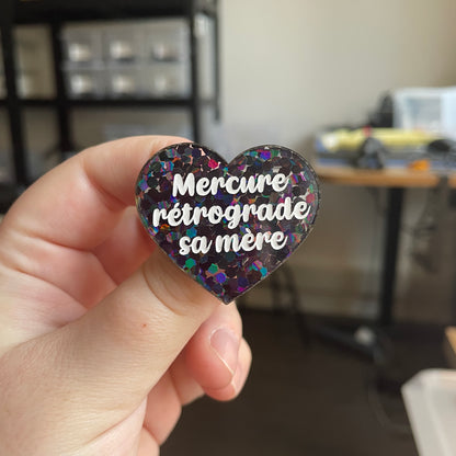 [CONTRÔLE TECHNIQUE] Broche "Mercure rétrograde sa mère" en acrylique semi-transparente avec des confettis noirs