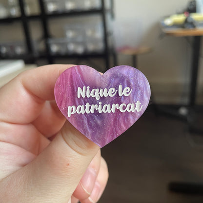 [CONTRÔLE TECHNIQUE] Broche "Nique le patriarcat" en acrylique marbrée bleue, rose et blanche à paillettes