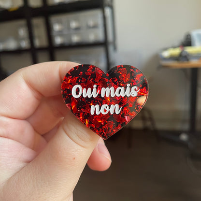 [CONTRÔLE TECHNIQUE] Broche "Oui mais non" en acrylique noire avec des éclats de confettis rouges