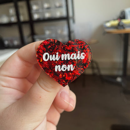 [CONTRÔLE TECHNIQUE] Broche "Oui mais non" en acrylique noire avec des éclats de confettis rouges