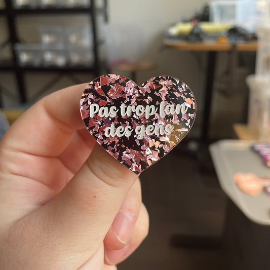 [CONTRÔLE TECHNIQUE] Broche "Pas trop fan des gens" en acrylique noire avec des éclats de confettis violets pâles