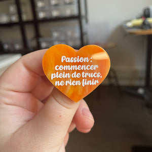[CONTRÔLE TECHNIQUE] Broche "Passion : commencer plein de trucs, ne rien finir" en acrylique marbrée orange et dorée à paillettes
