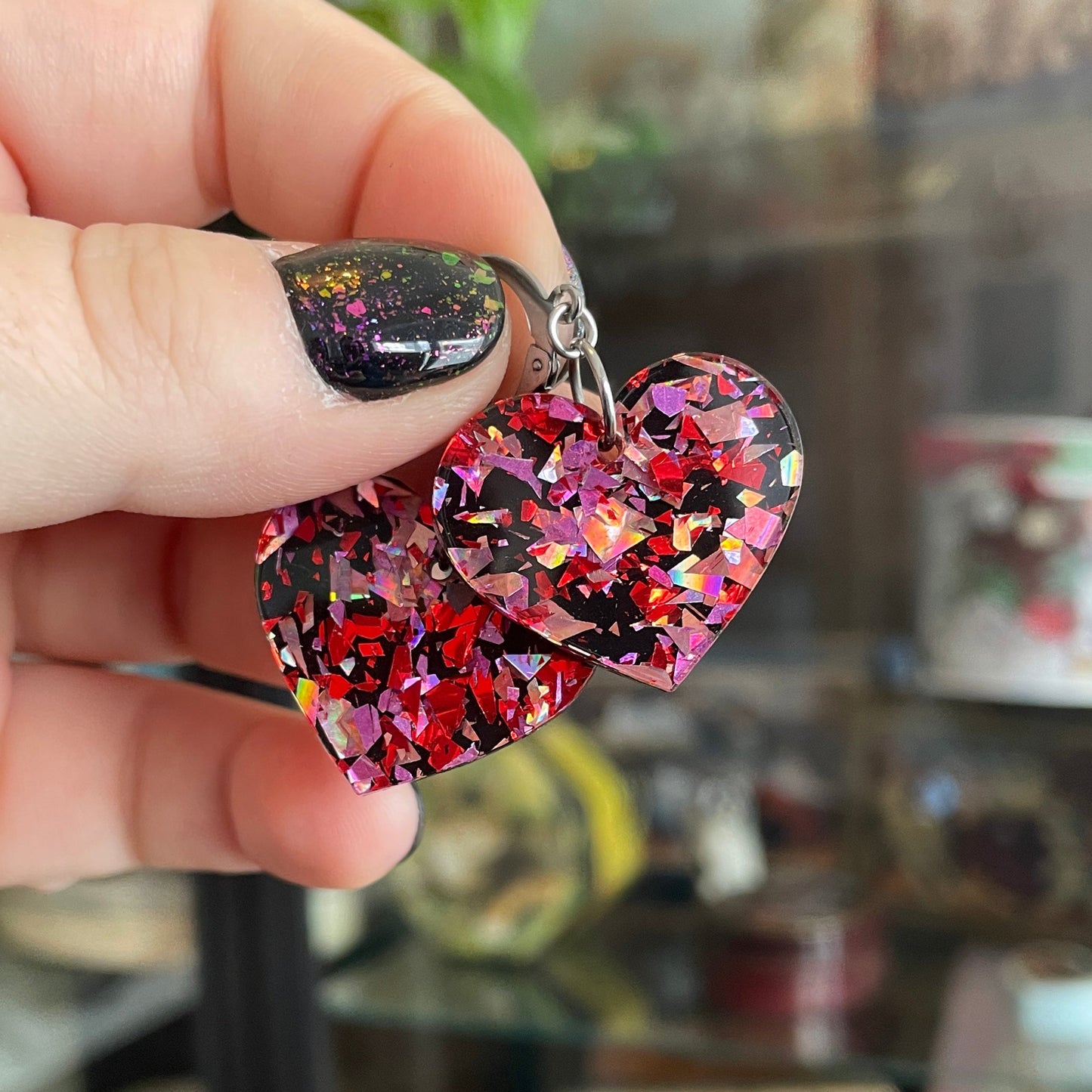 Petites boucles d'oreilles coeurs pendantes en acrylique noire avec des confettis galactiques rouges et roses