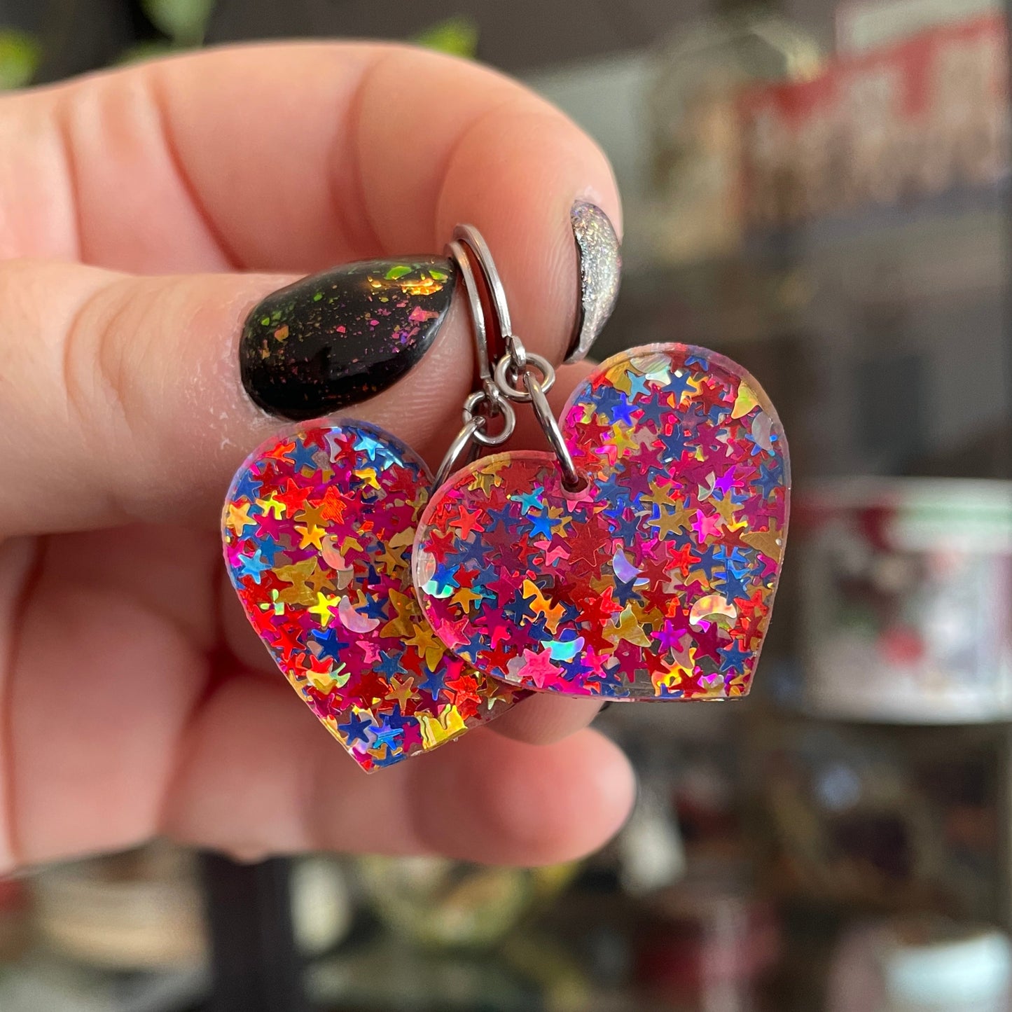 Petites boucles d'oreilles coeurs pendantes en acrylique avec des confettis étoiles et lunes multicolores