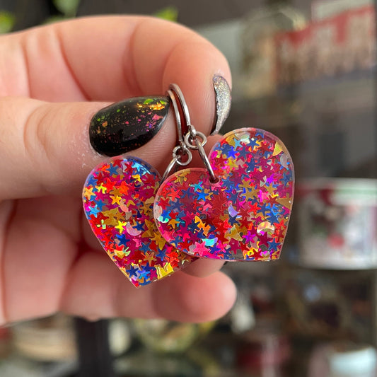 Petites boucles d'oreilles coeurs pendantes en acrylique avec des confettis étoiles et lunes multicolores
