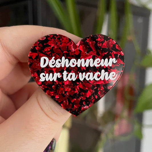 Broche "Déshonneur sur ta vache" en acrylique noire avec des éclats de confettis rouges
