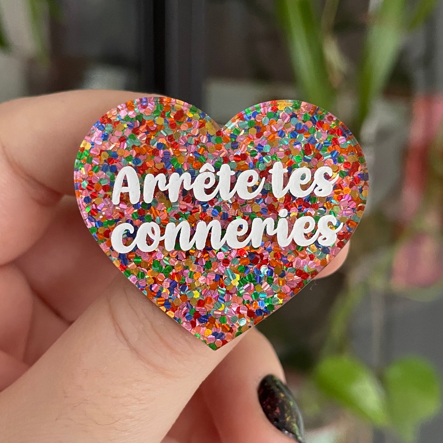 Broche "Arrête tes conneries" en acrylique avec des confettis multicolores